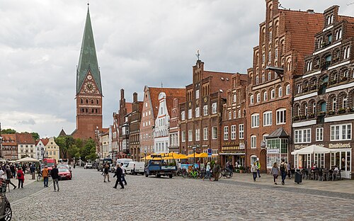 Der Platz Am Sande in Lüneburg mit Backsteingiebeln und der St.-Johannis-Kirche im Hintergrund